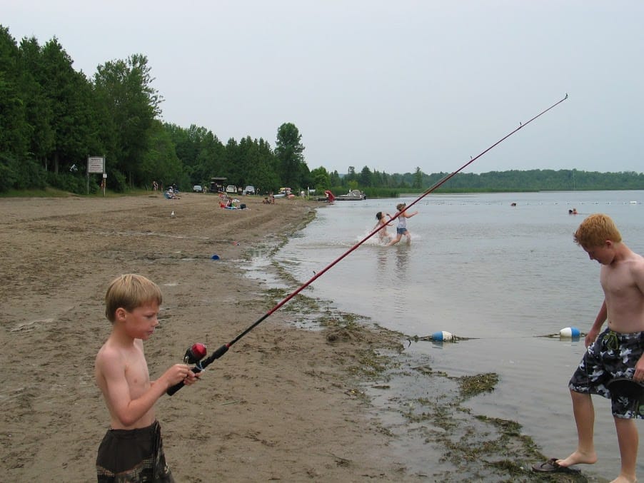 Picture of Thomas on beach fishing at Emily Provincial Park in the summer while camping.
